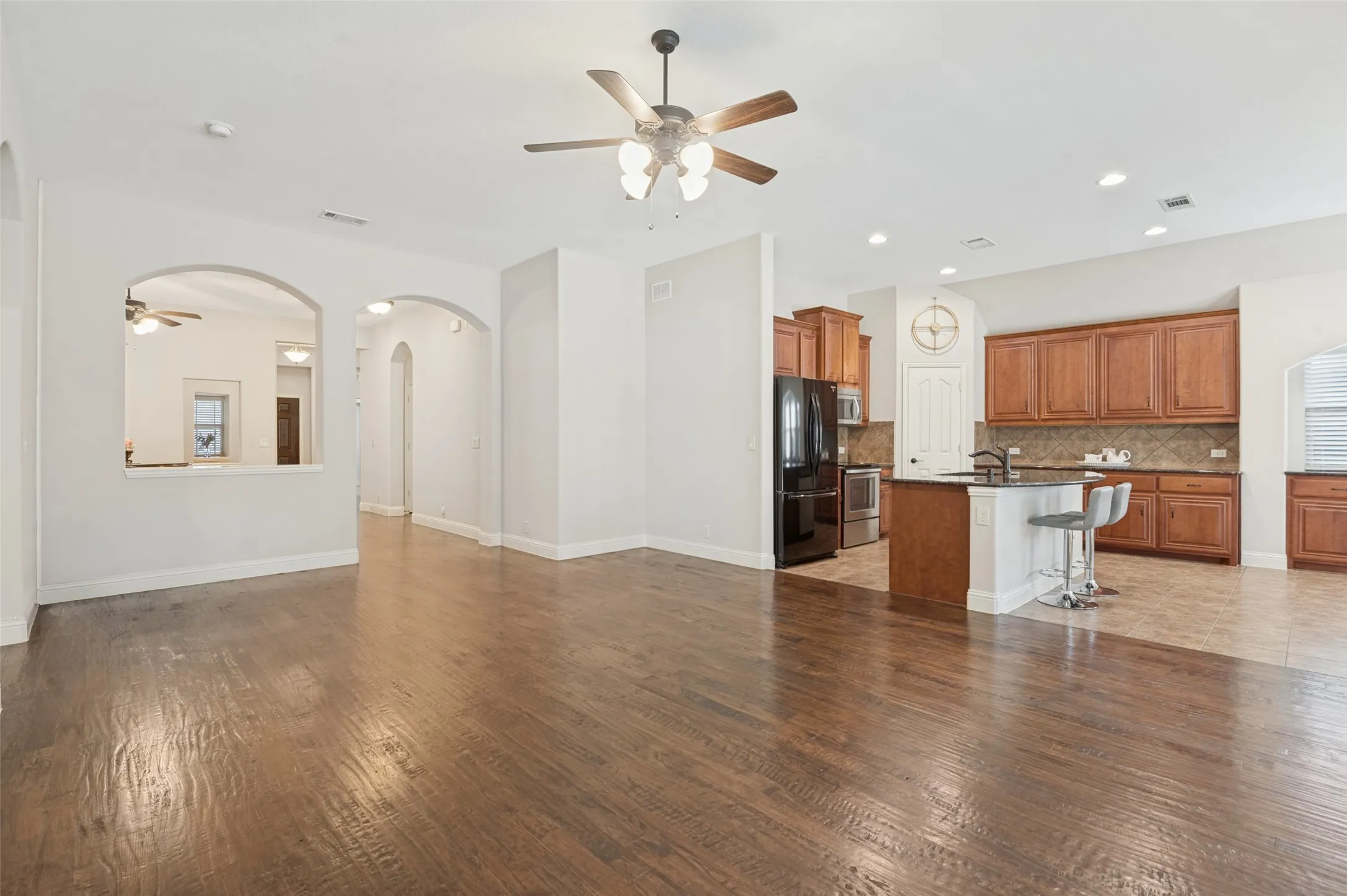 Wood-finish flooring throughout, with a ceiling fan