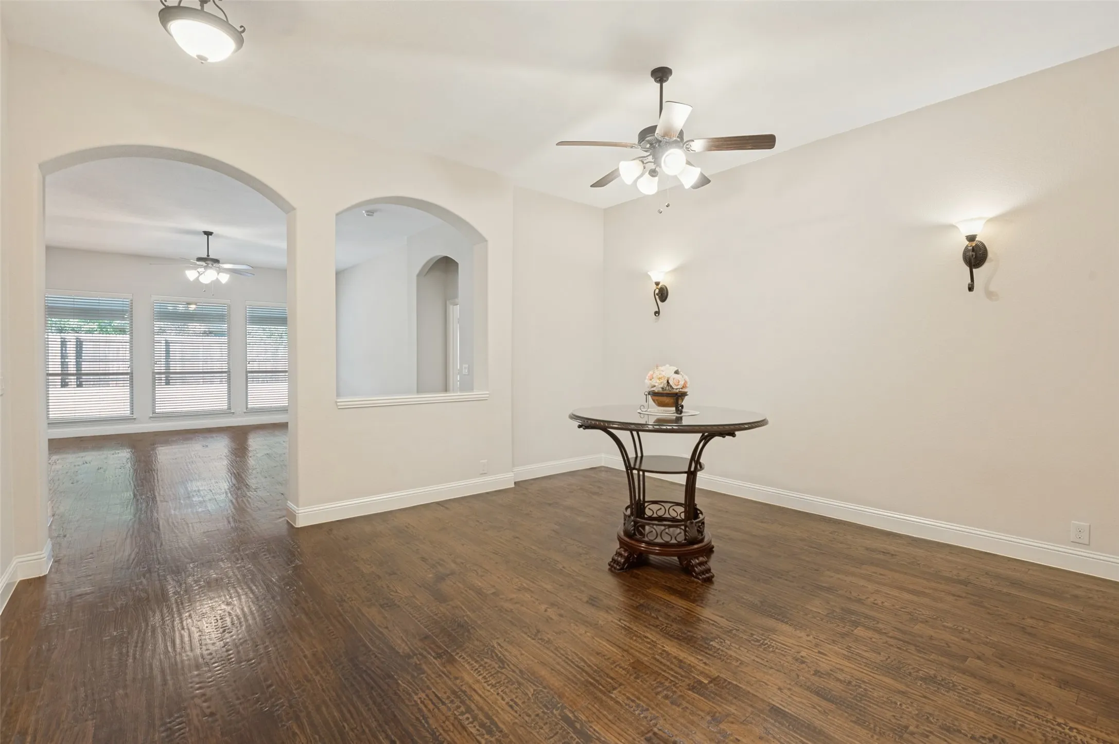 Wood-finish flooring, recessed lighting, arched doorways, and a ceiling fan