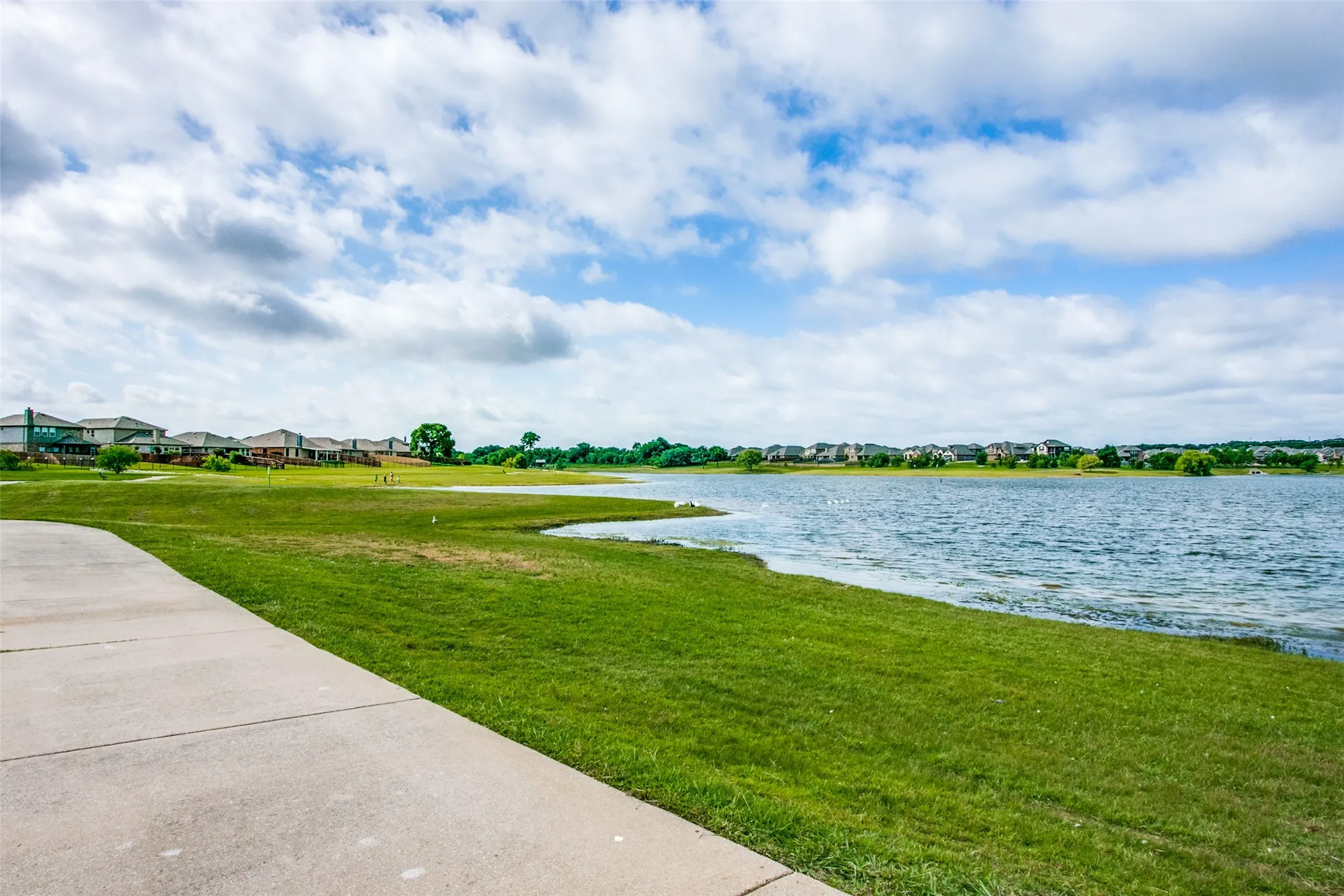 Walking Trails property featuring a concrete pathway, large grassy areas and plenty of fishing opportunities