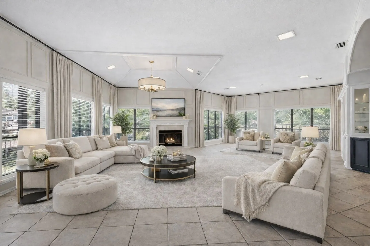 Virtually Staged Spacious living area featuring large windows, a central fireplace with a mantel, tile flooring, built-in cabinetry, and a coffered ceiling