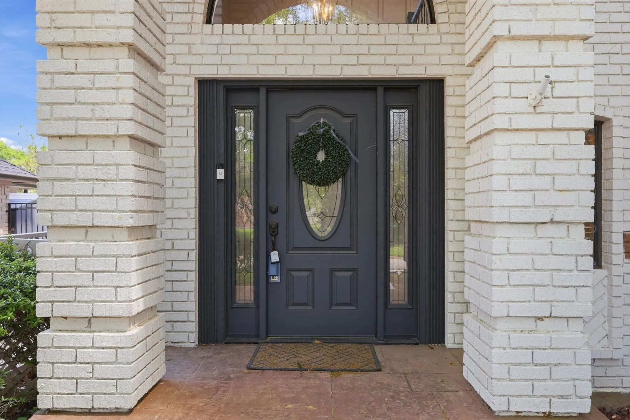 Entryway featuring a dark paneled door with leaded glass, side lights, and a decorative arch transom
