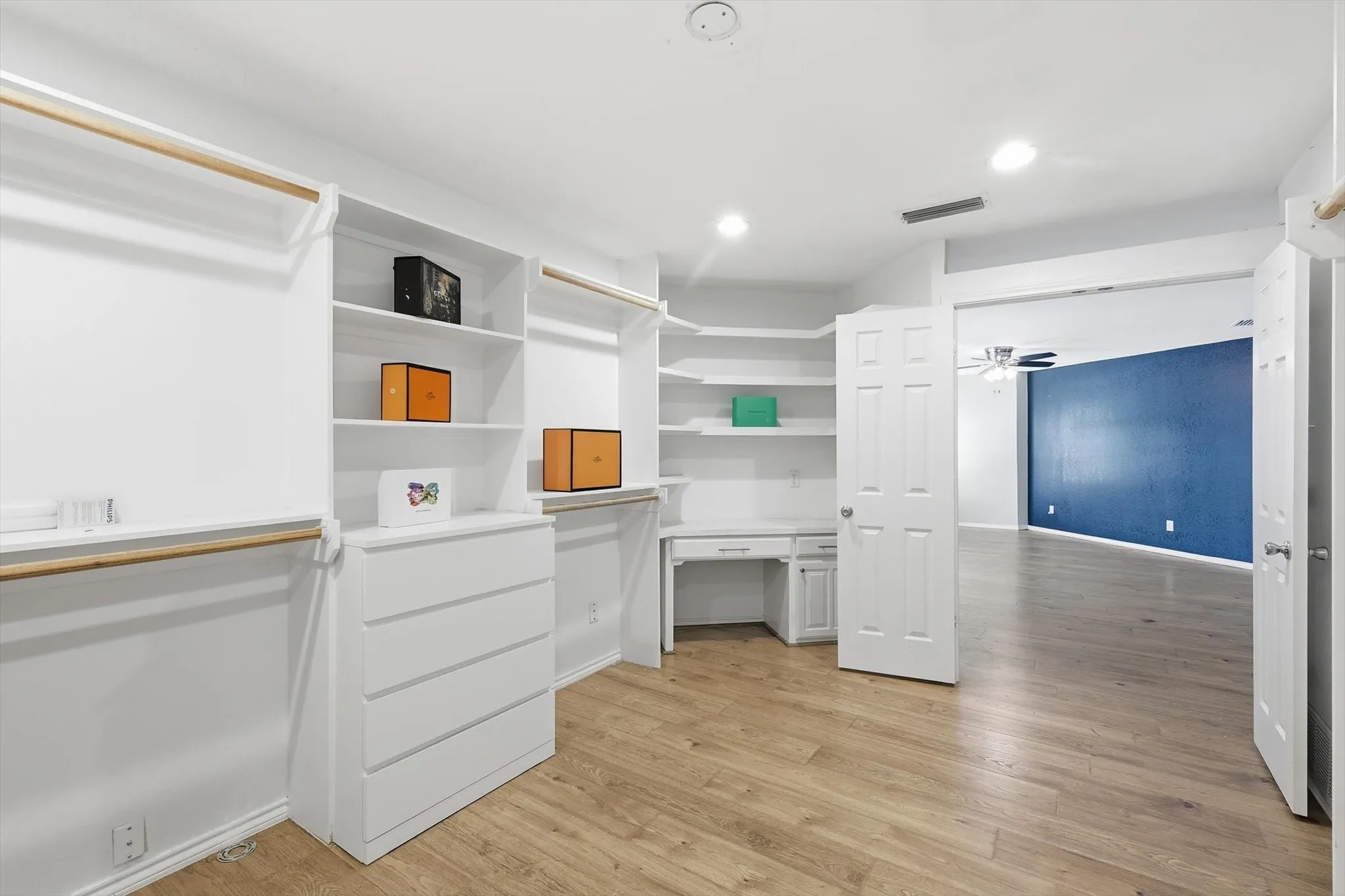 White built-in cabinetry, wood-finish flooring, recessed lighting, and a built-in desk