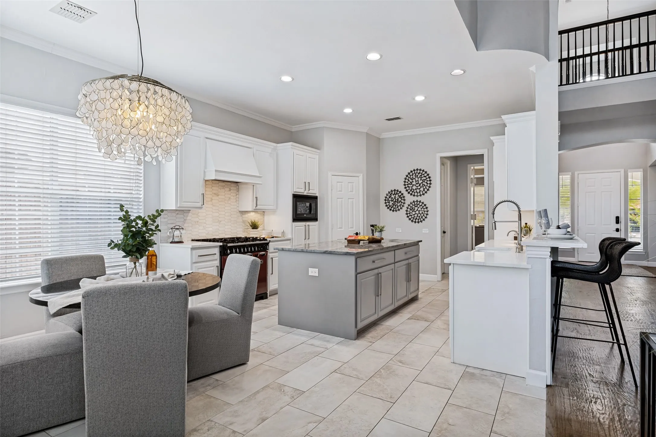 Kitchen featuring a central island with countertop, white cabinetry, integrated oven, and tile flooring