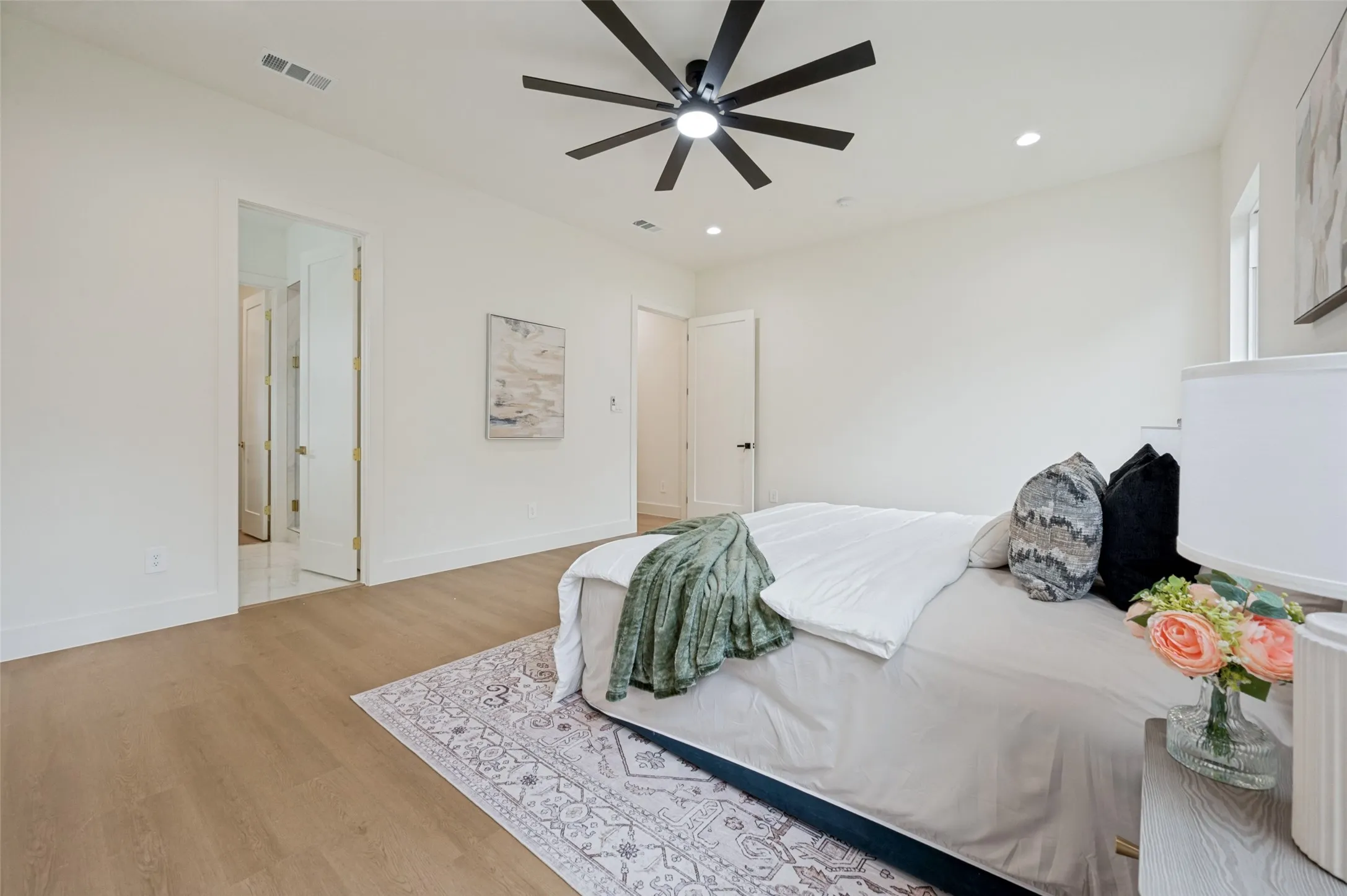 Wood-finish flooring, recessed lighting, ceiling fan, and white walls
