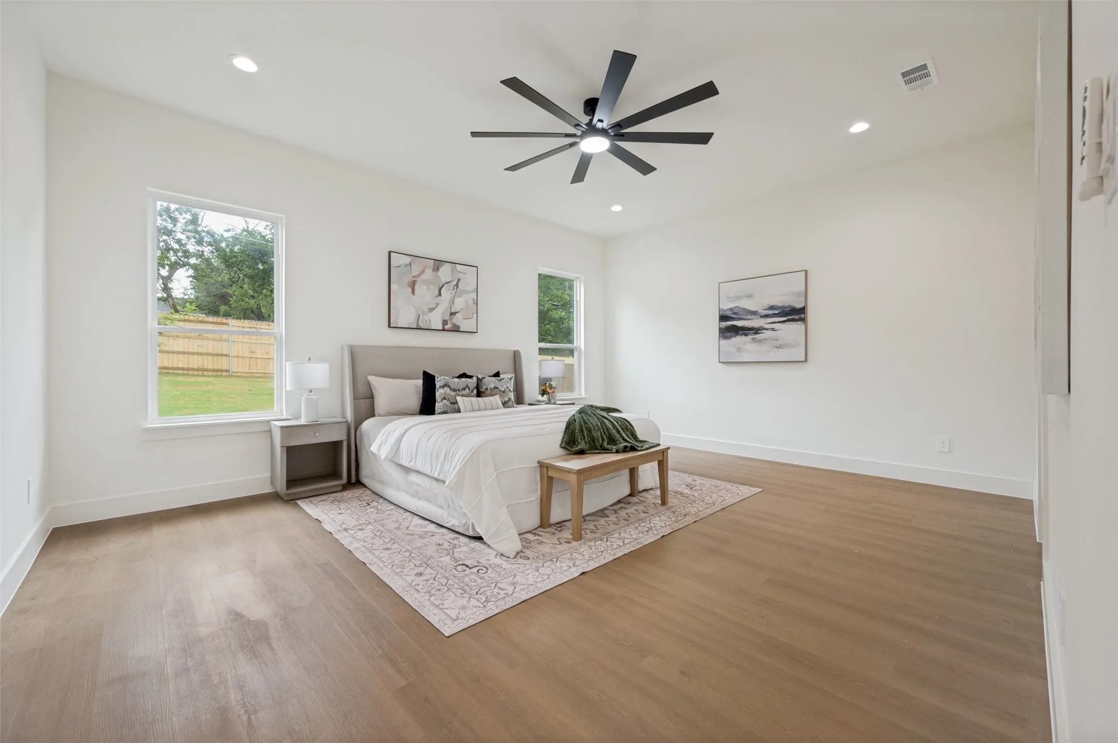 Spacious room featuring wood-finish flooring, recessed lighting, and a contemporary ceiling fan