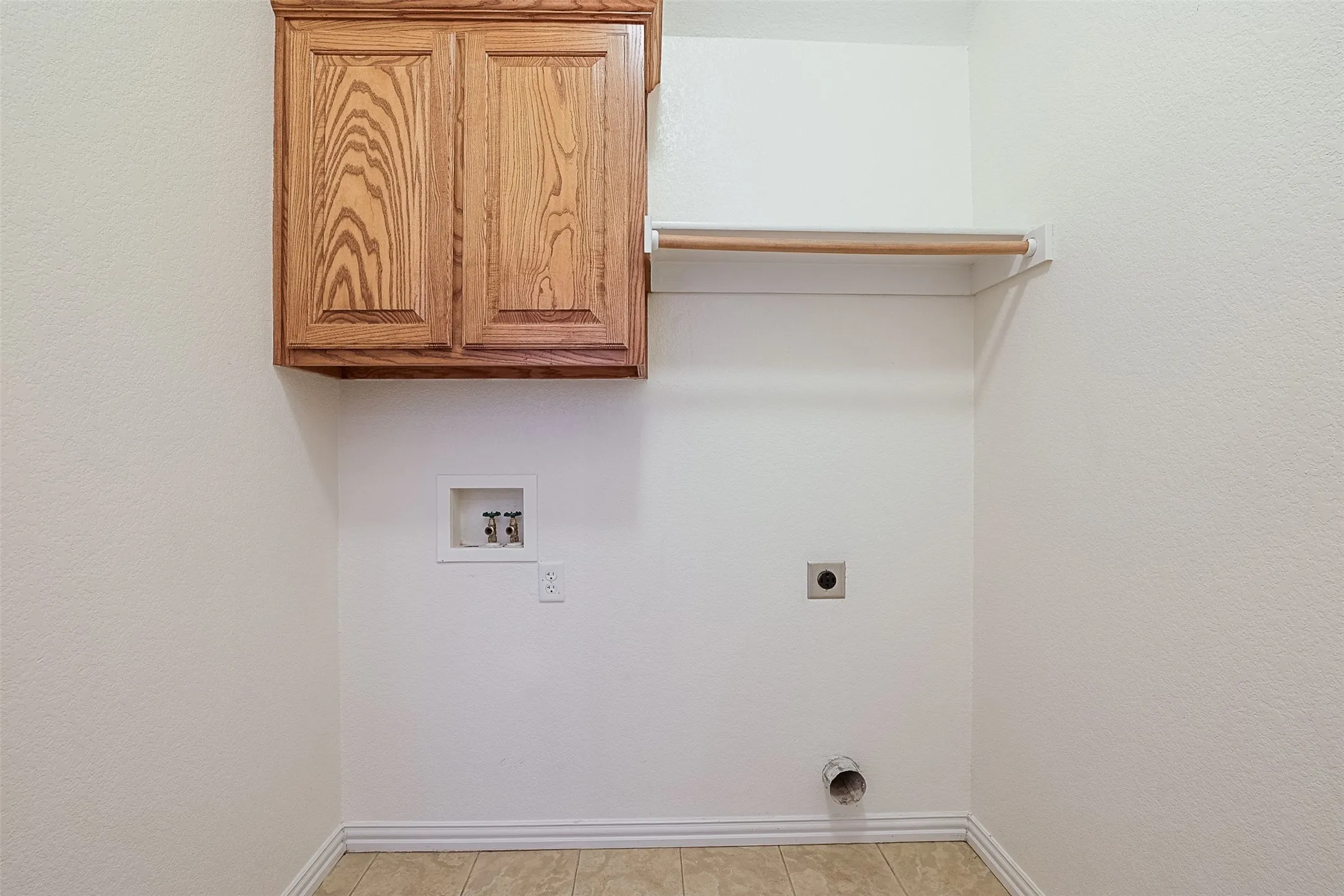 Hardwood cabinetry with wood-finish shelving and tile flooring