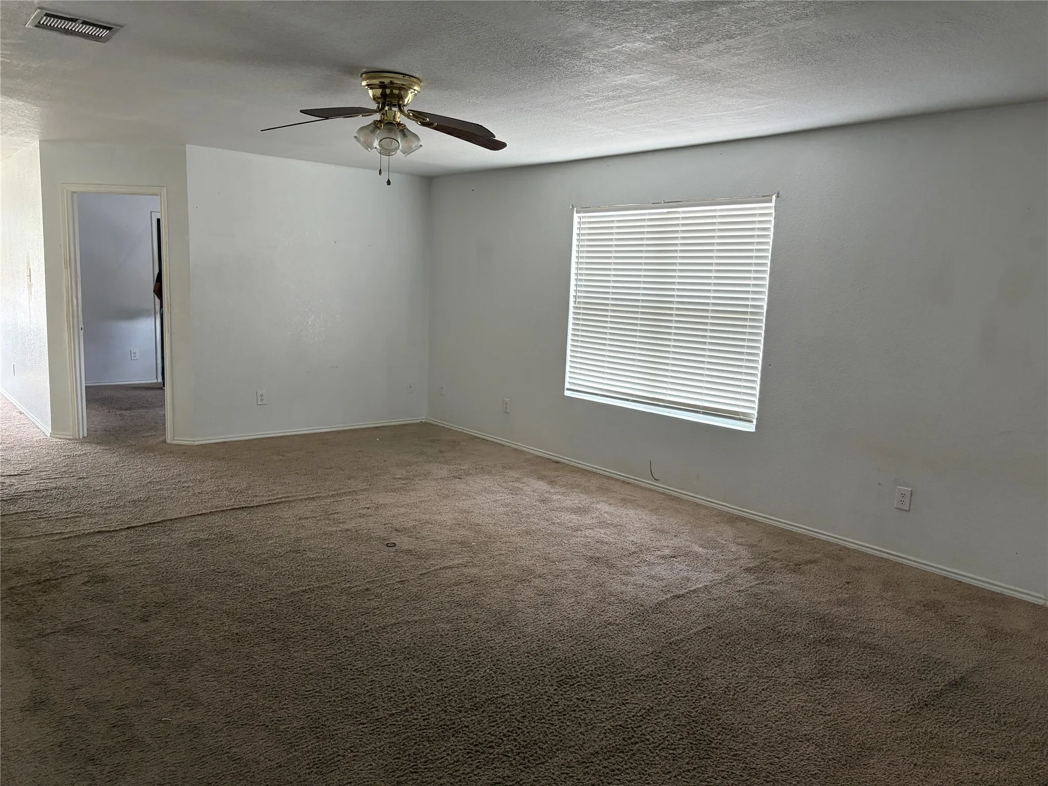 Neutral wall color, carpeted flooring, ceiling fan with light fixture, and window with blinds