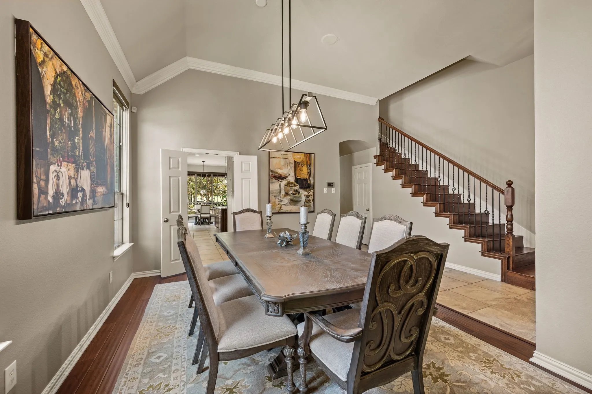 Elegant formal dining room features a vaulted ceiling, statement lighting & easy access to the kitchen.