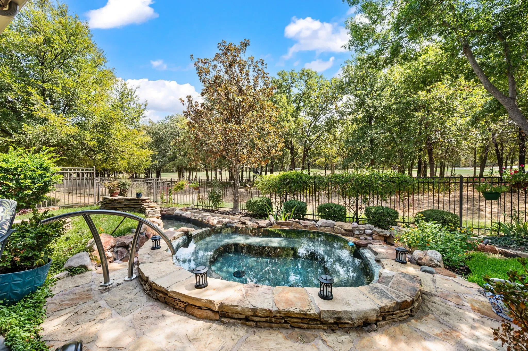 Sparkling pool with natural stone accents creates a serene backyard retreat overlooking the golf course.