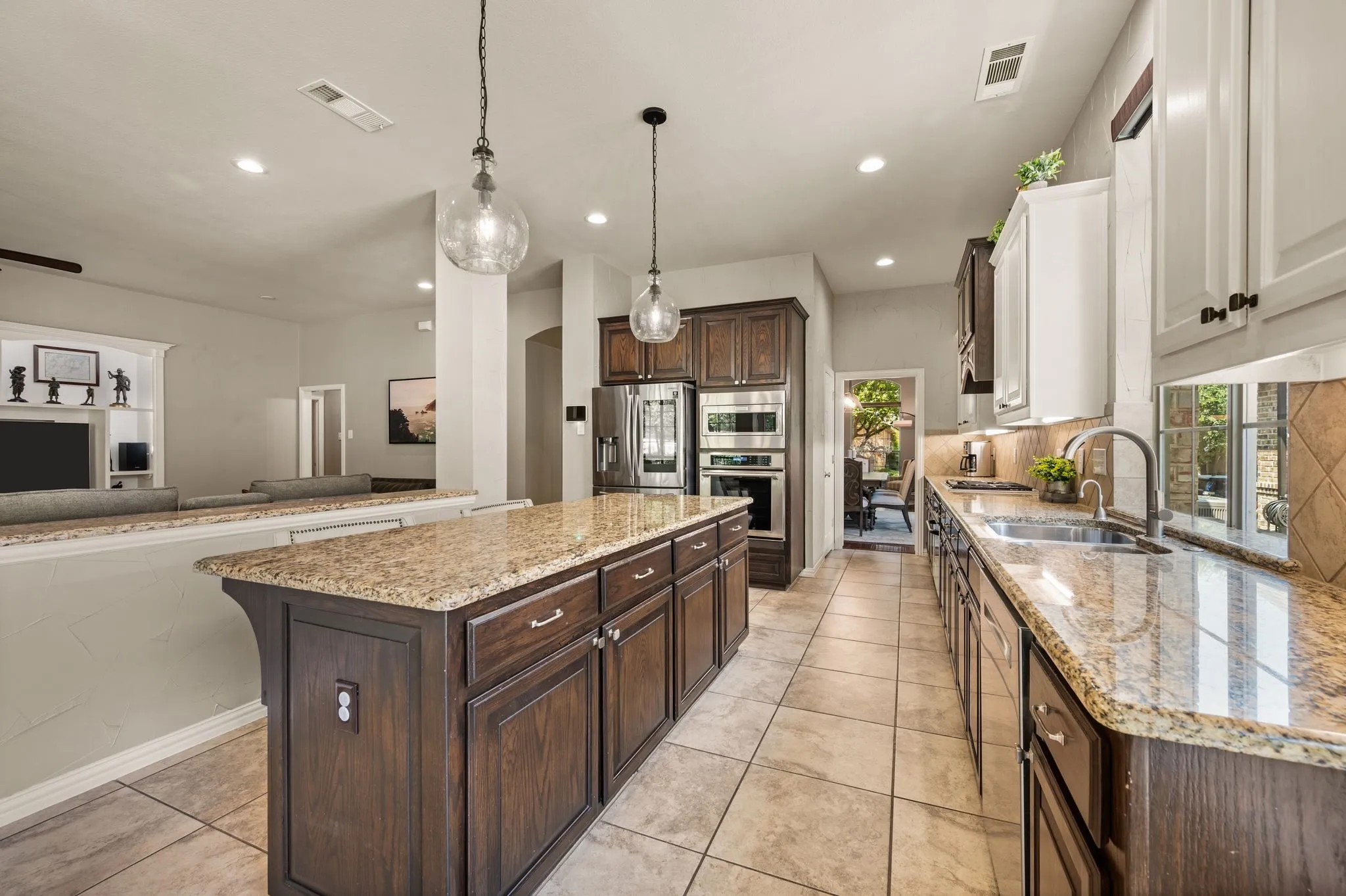 Spacious kitchen offers an oversized granite island, abundant cabinetry, stainless steel appliances & open flow to the living room.