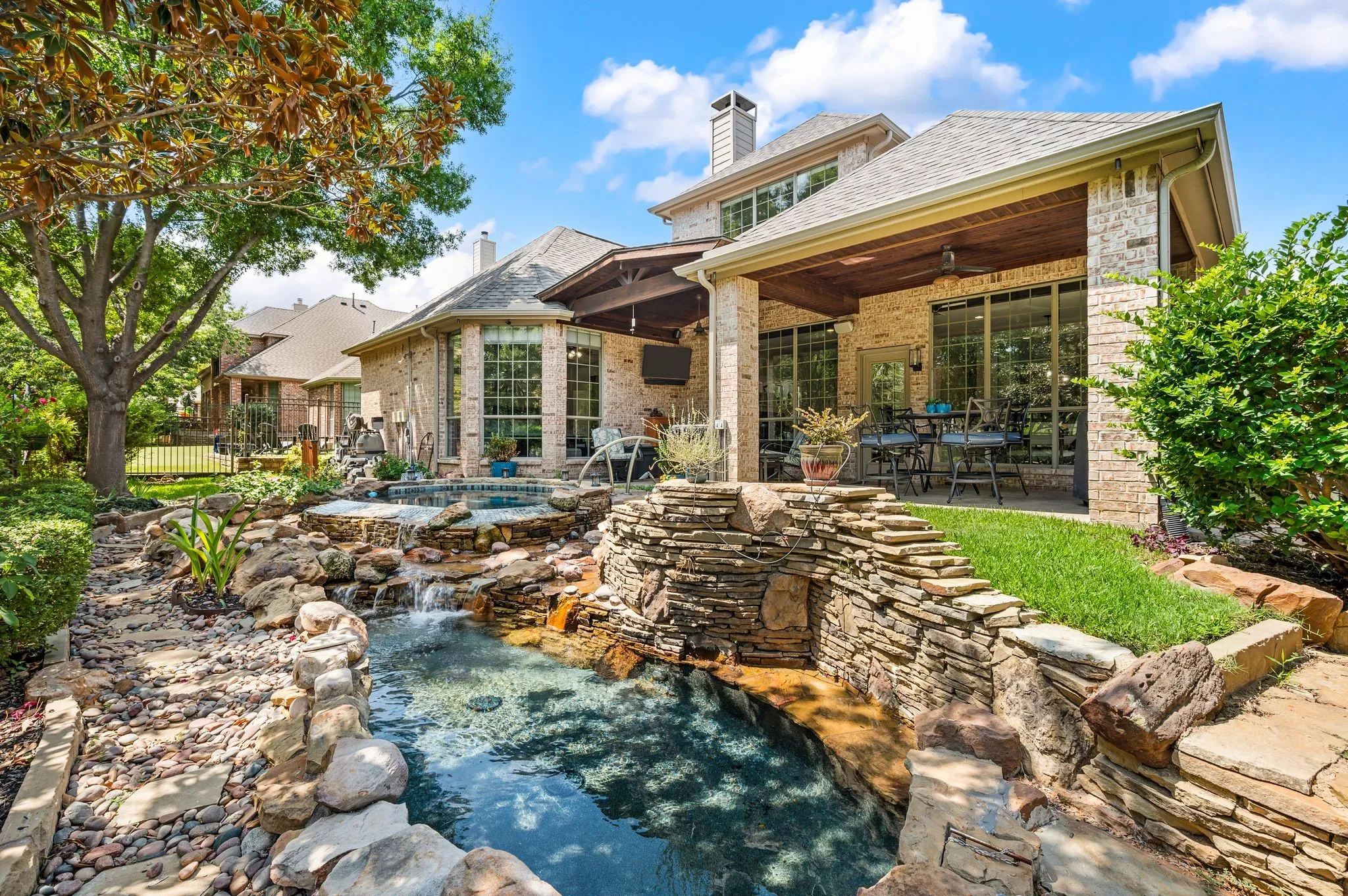 Backyard paradise with a cascading water features, gorgeous stonework & expansive covered outdoor living.