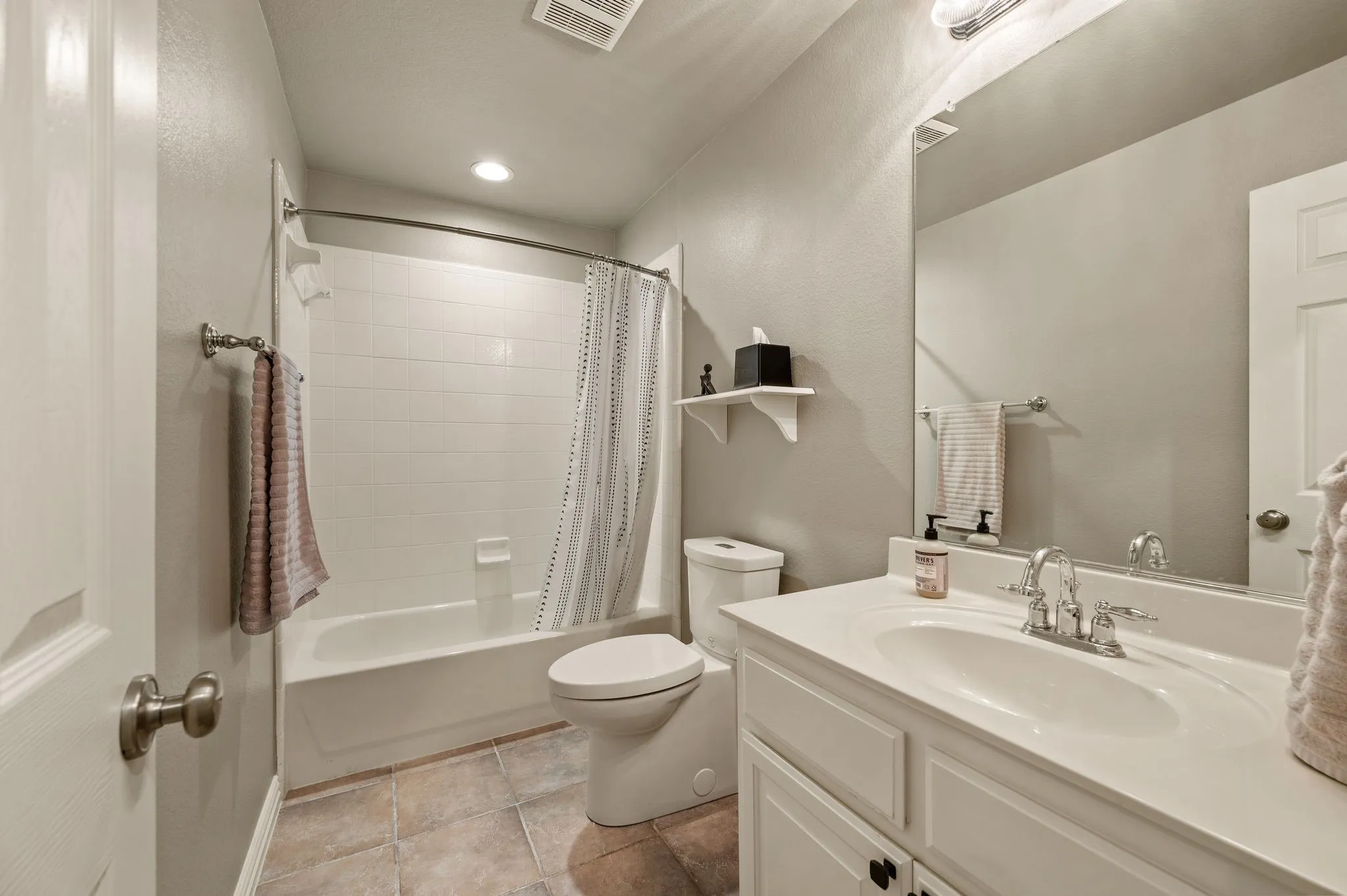 Full upstairs bathroom features a tub and shower combination, spacious vanity & neutral finishes.