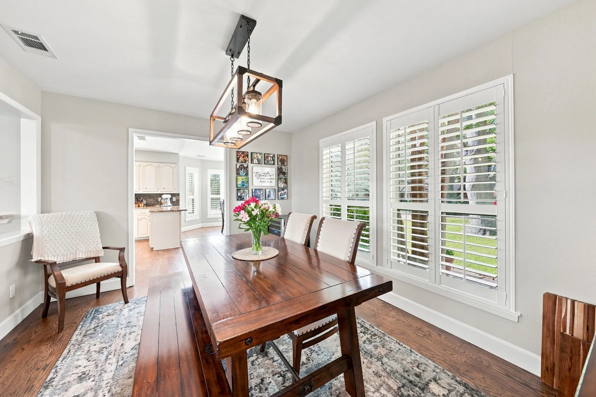 Hardwood-finish flooring, white window shutters, and a rectangular light fixture with multiple bulbs