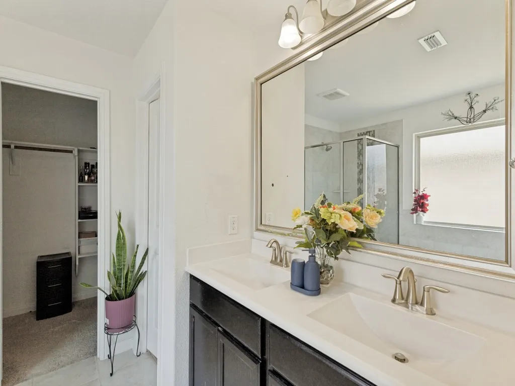 Dual vanity with undermount sinks, bronze finish fixtures, and a framed mirror