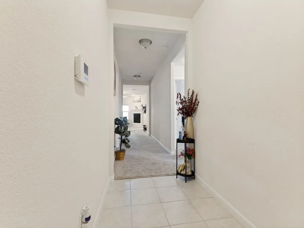 Hallway featuring tile flooring, neutral wall tones, and recessed lighting