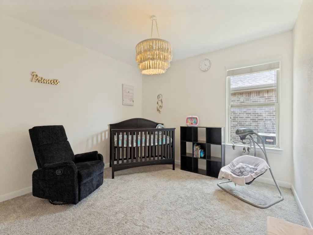 Recessed ceiling with a decorative chandelier, neutral wall paint, and light-toned carpet