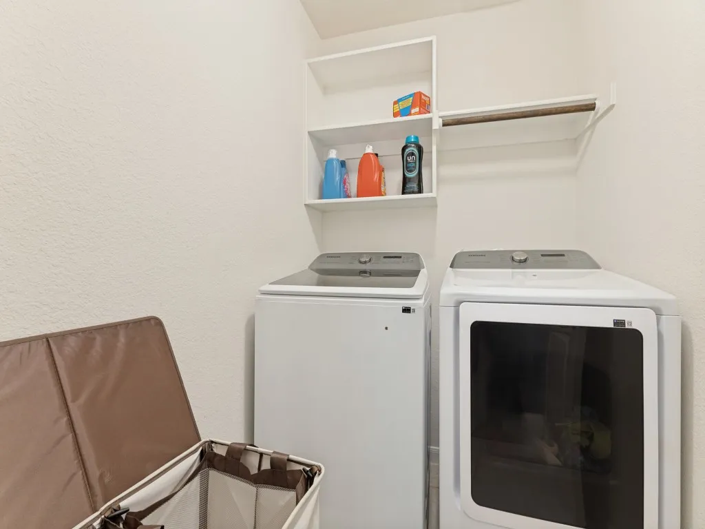Dedicated laundry area featuring built-in shelving and a clothing rod