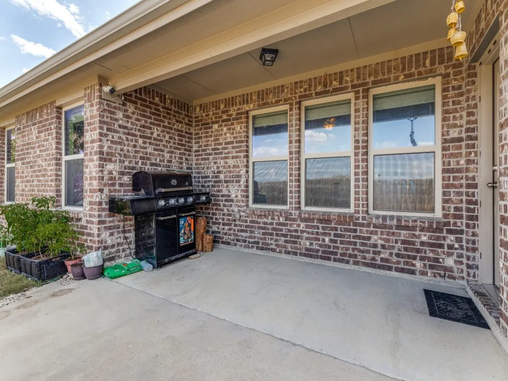 Covered patio with brick exterior and concrete flooring
