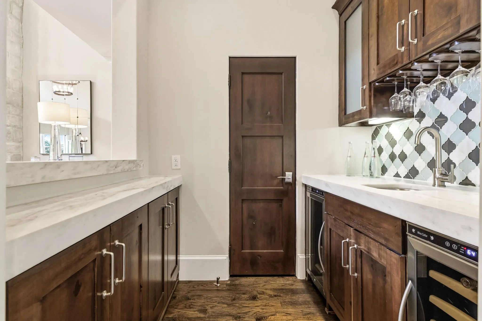 Wet bar featuring a wine fridge, beverage fridge and storage. Temperature controlled wine storage also featured in this home.