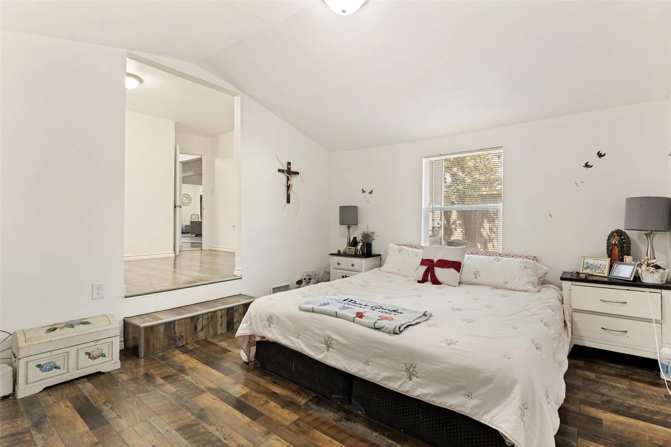 Vaulted ceiling, wood-finish flooring, recessed lighting, and a window for natural light