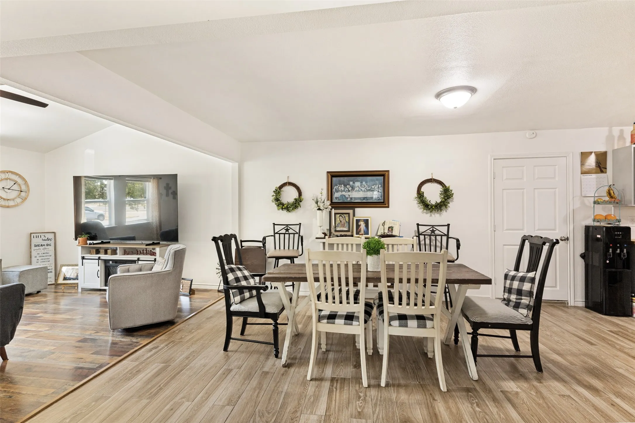 Spacious open-concept interior with wood-finish flooring, white walls, and recessed lighting