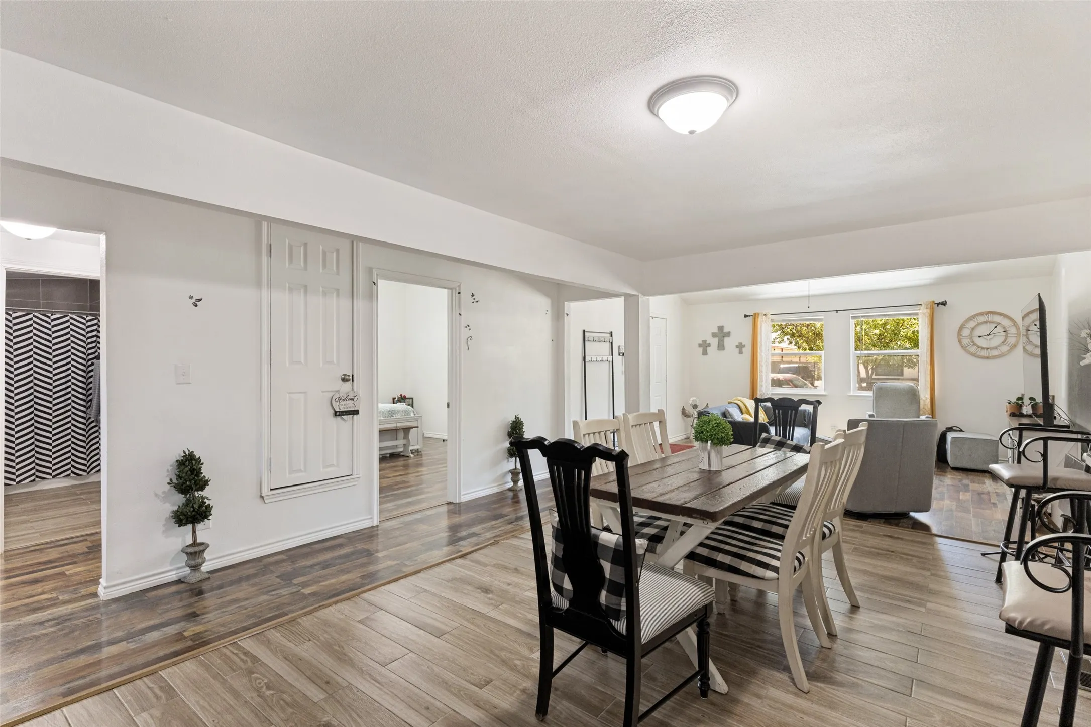 Wood-finish flooring throughout, white painted walls, and a ceiling-mounted light fixture