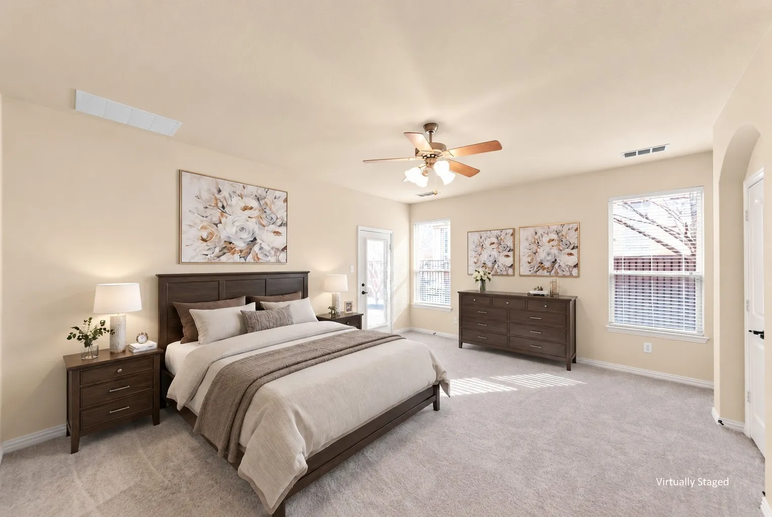 Plush carpeting, multiple windows with blinds, ceiling fan, and an arched entryway