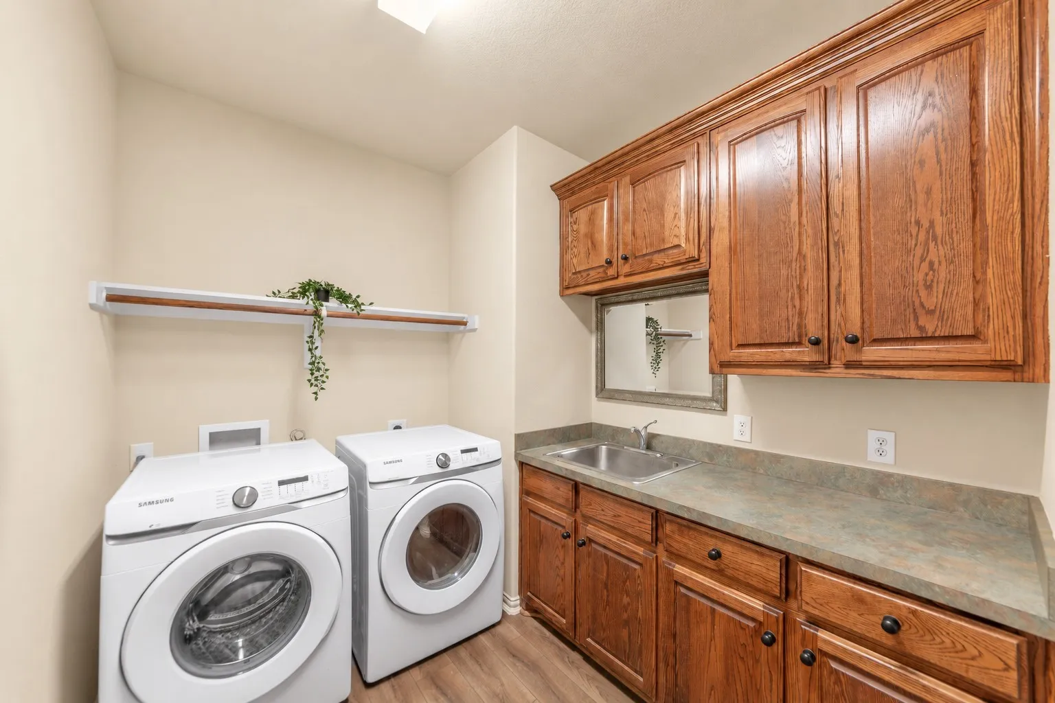 Wood-finish flooring, built-in wooden cabinetry, integrated sink, and countertop
