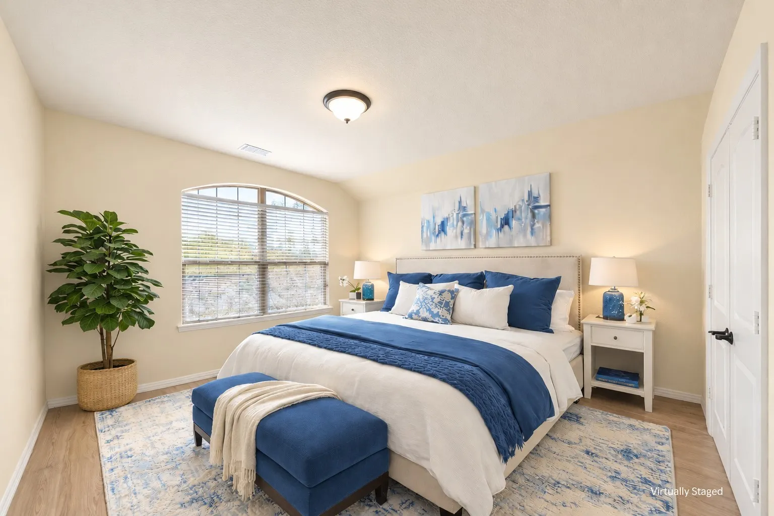 Arched window with blinds, wood-finish flooring, white paneled door with dark hardware, permanent overhead lighting, light-colored walls