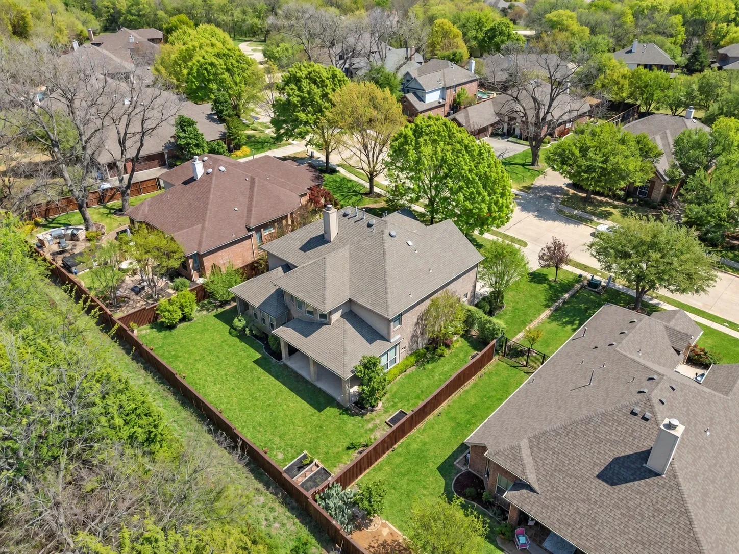 Brick exterior, multi-level roofline, fenced backyard, covered patio, mature trees