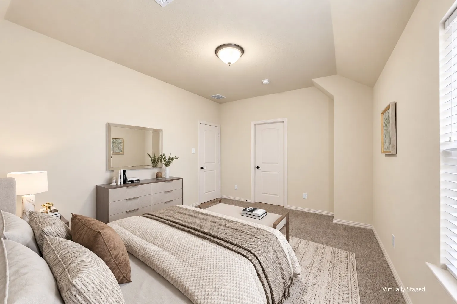 Vaulted ceiling with an overhead light fixture, carpeted flooring, and a window with blinds