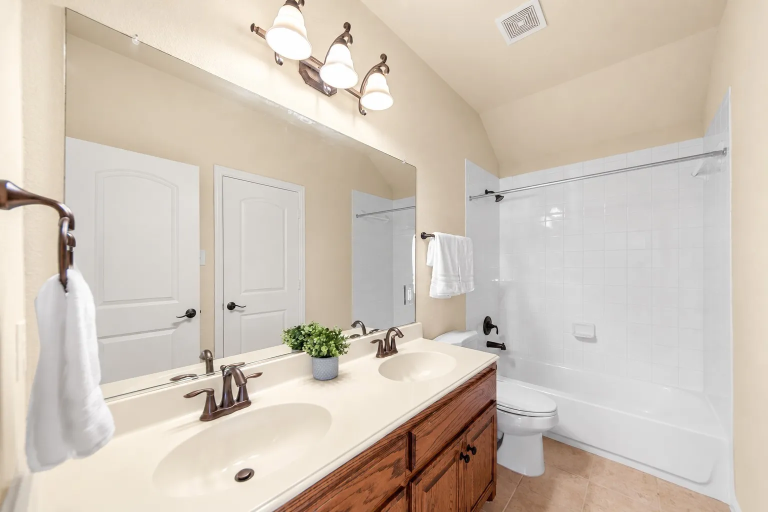 Dual basin vanity with a wood-finish cabinet and bronze fixtures