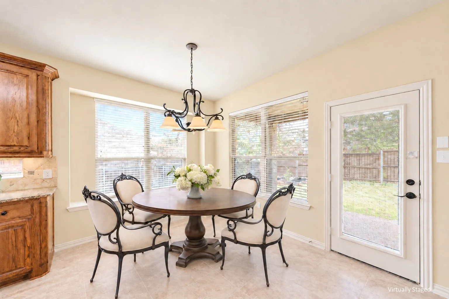 Warm-toned cabinetry with granite-style countertops, mosaic tile backsplash, and an integrated corner sink