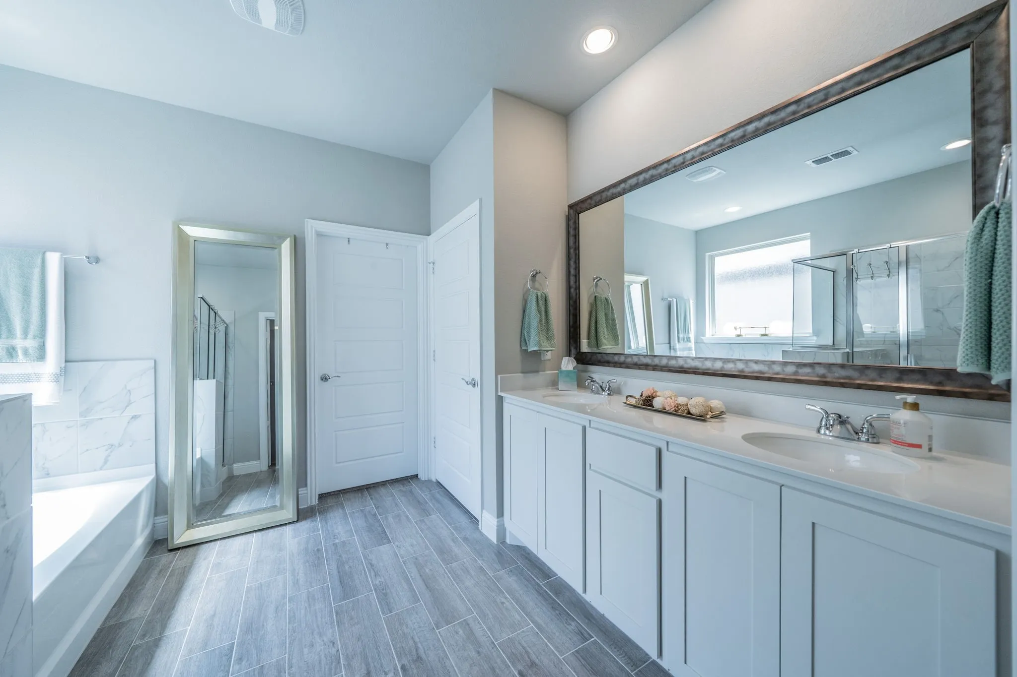 Primary bathroom with dual sinks and natural light.