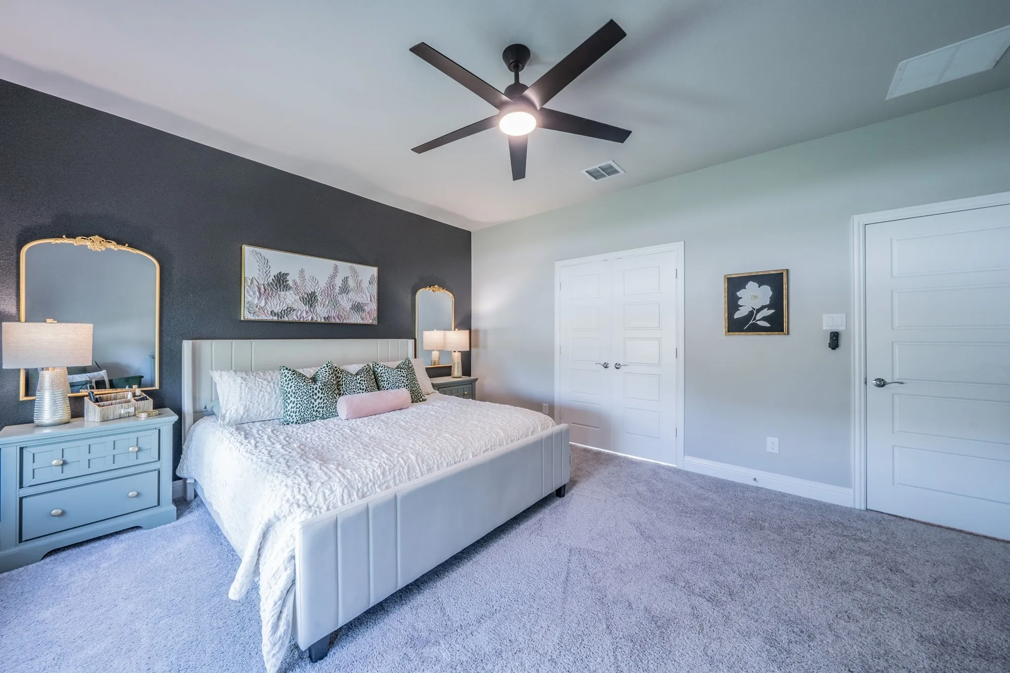Another view of the spacious primary bedroom facing the bathroom double doors.