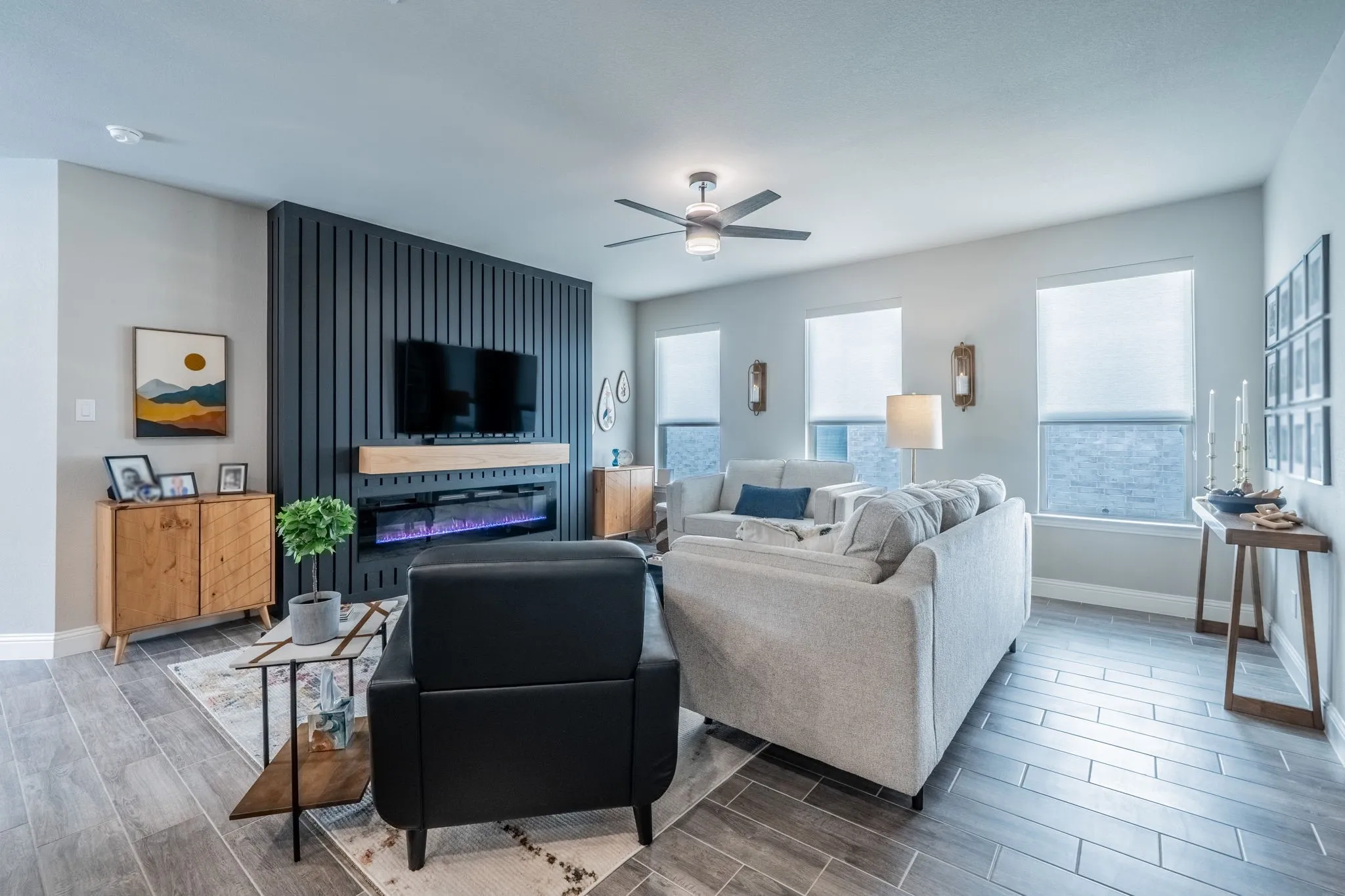 Another view of the living space facing the electric fireplace and windows.