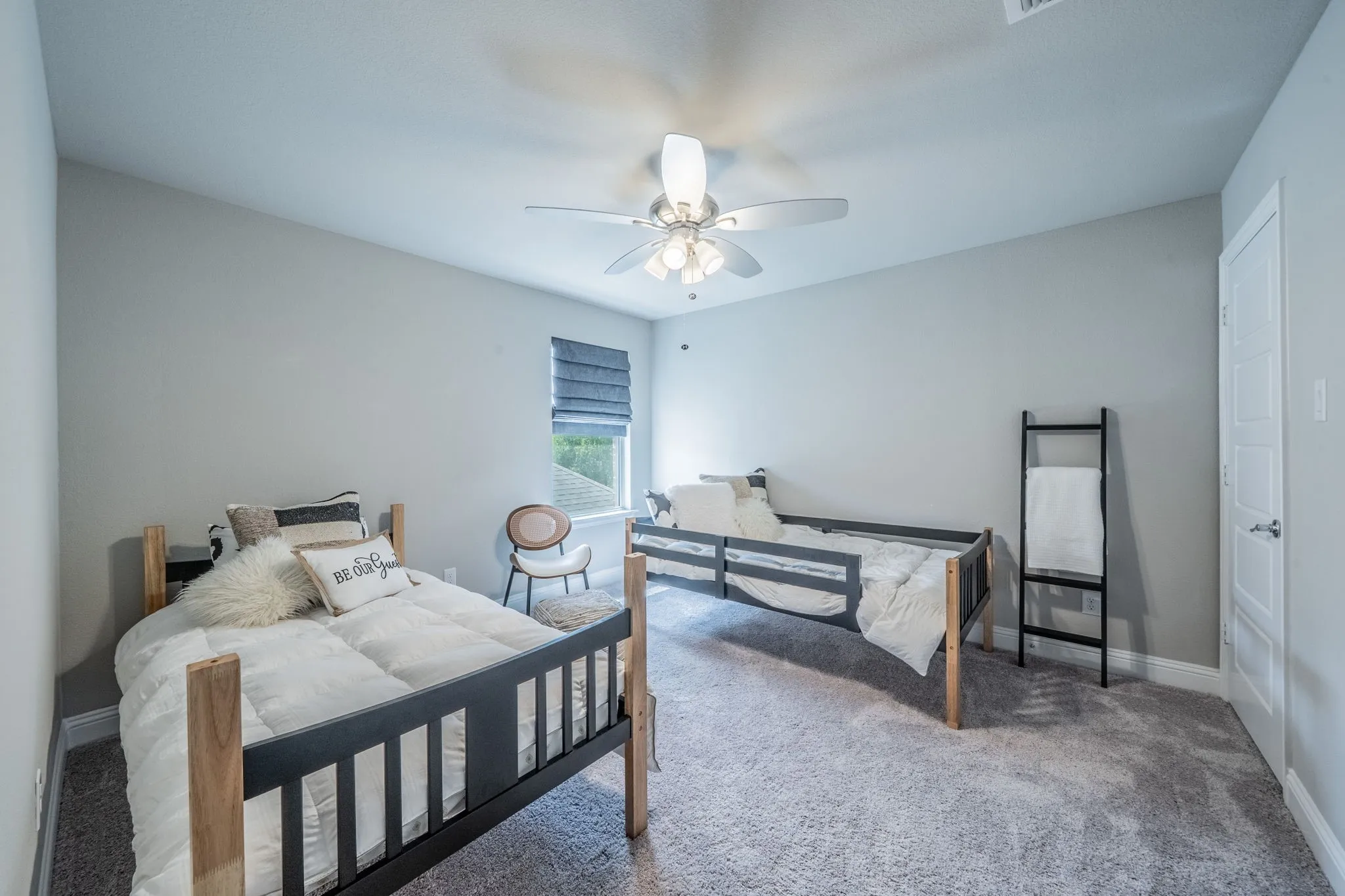 Bedroom 2 featuring a walk-in closet, upgraded ceiling fan, and natural light.