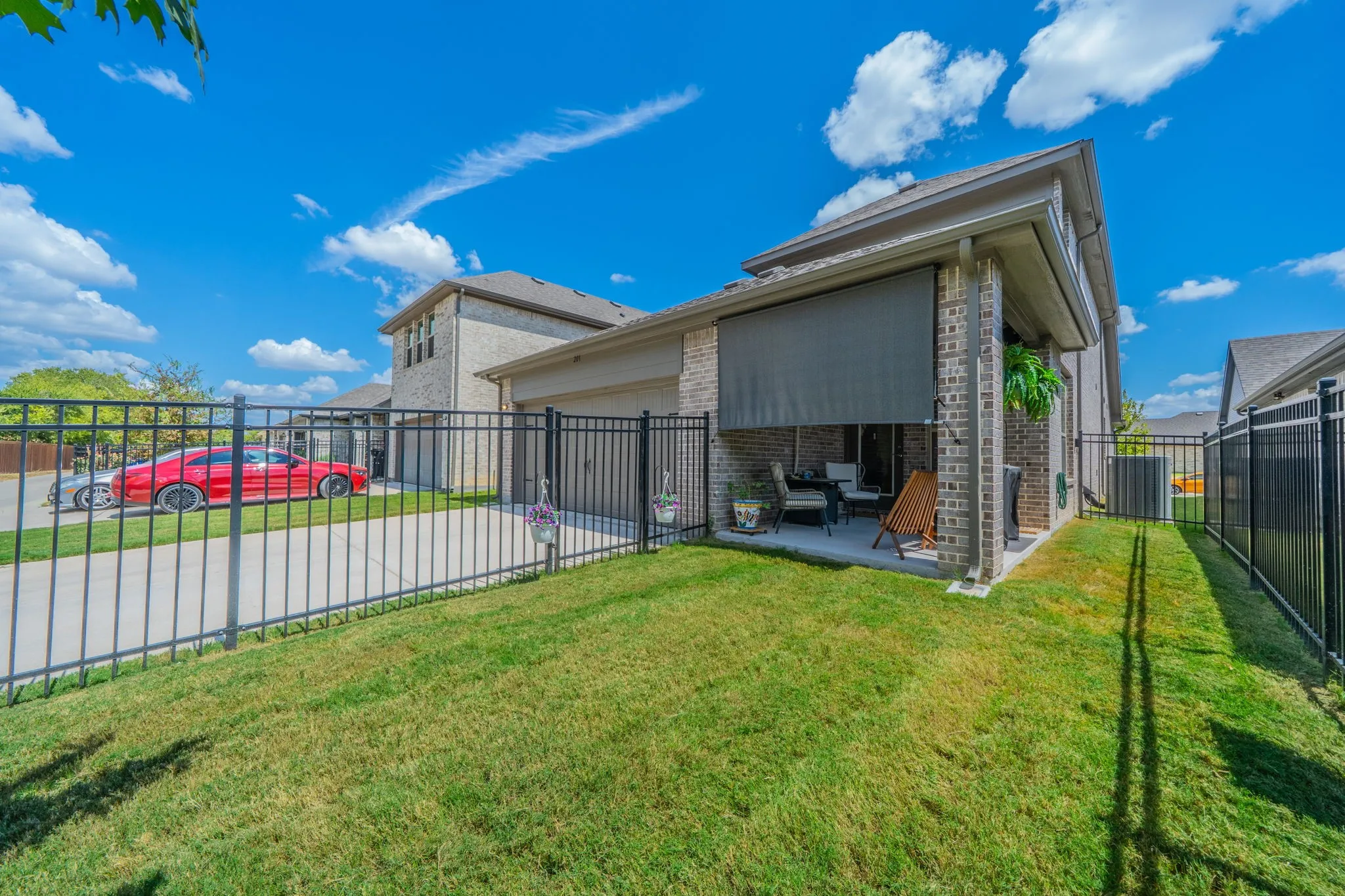 View of the back yard with covered patio and shade for convenience!