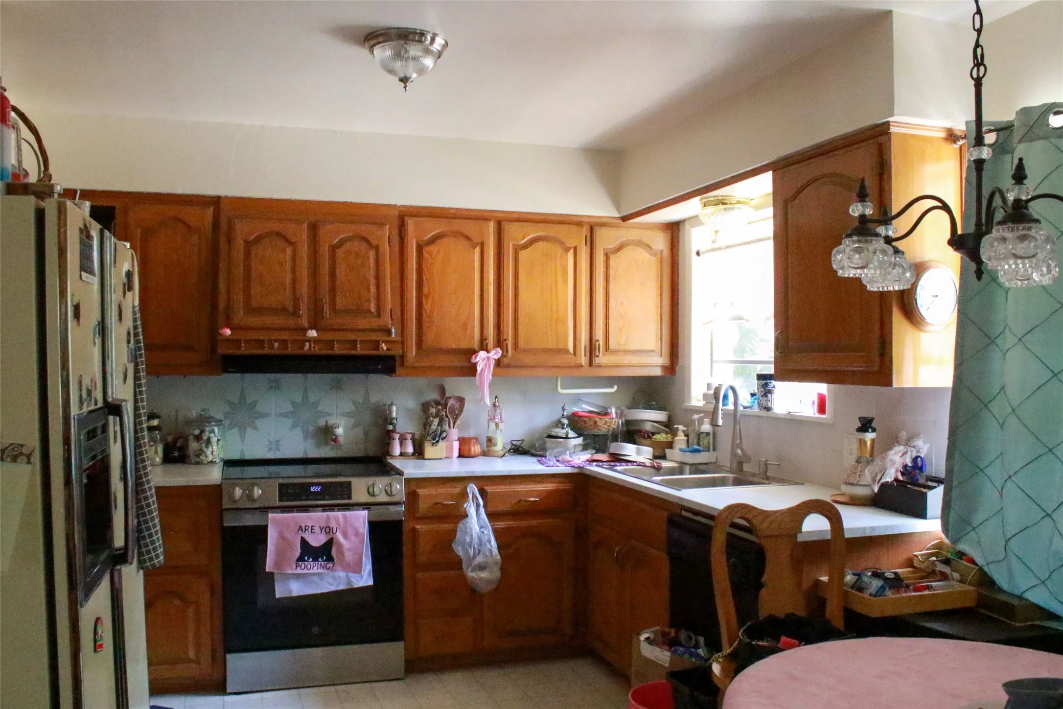 Kitchen featuring wood-finish cabinetry, built-in stainless steel appliances, and a double basin sink