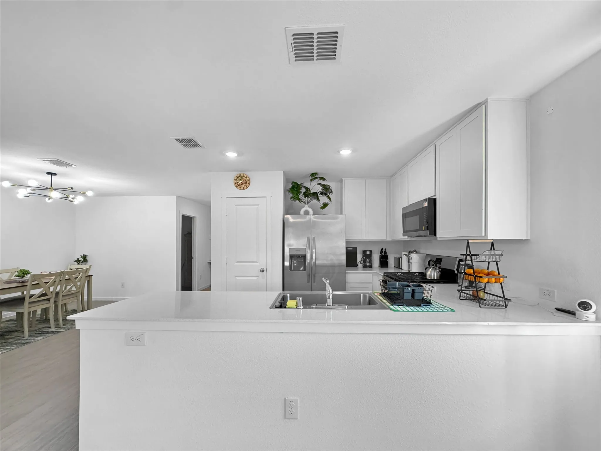 Spacious kitchen featuring white cabinetry, stainless steel appliances, a double basin sink, and ample countertop space