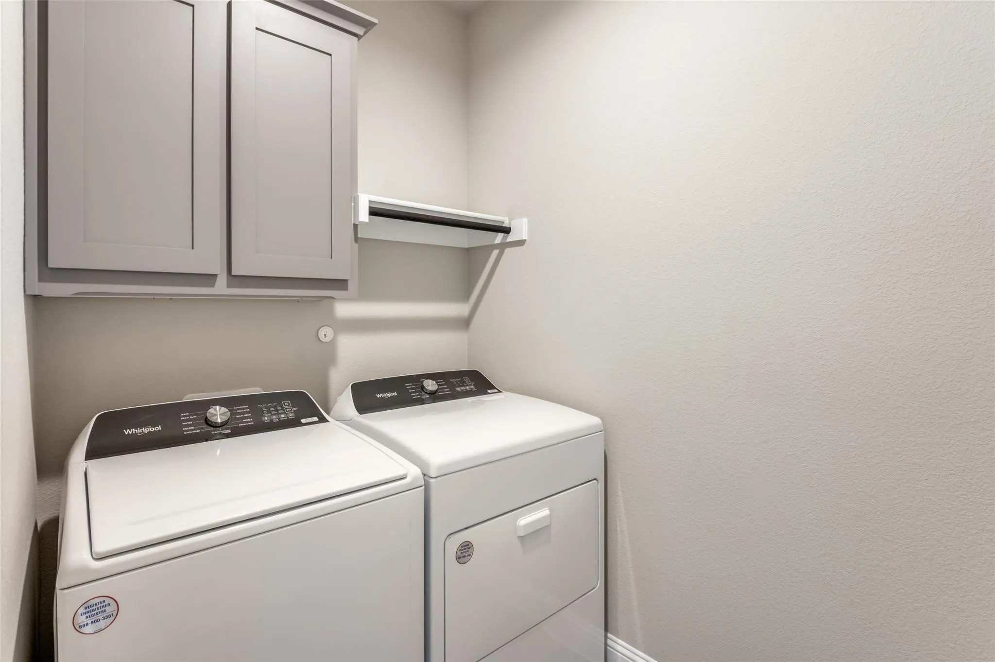 Built-in cabinetry with gray shaker-style doors and a white shelving unit for organization