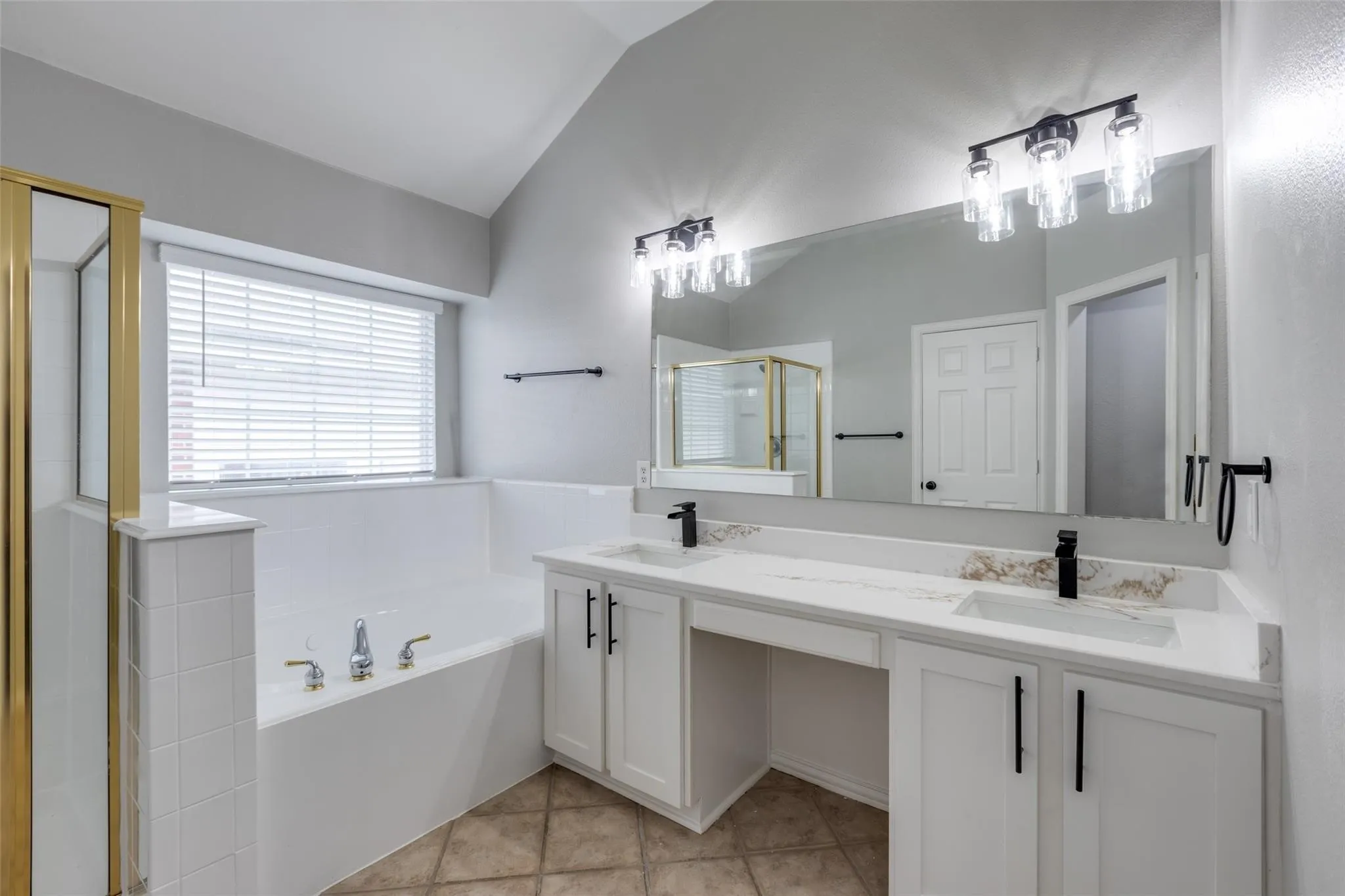 White vanity with dual integrated sinks, quartz-finish countertop, and black fixtures