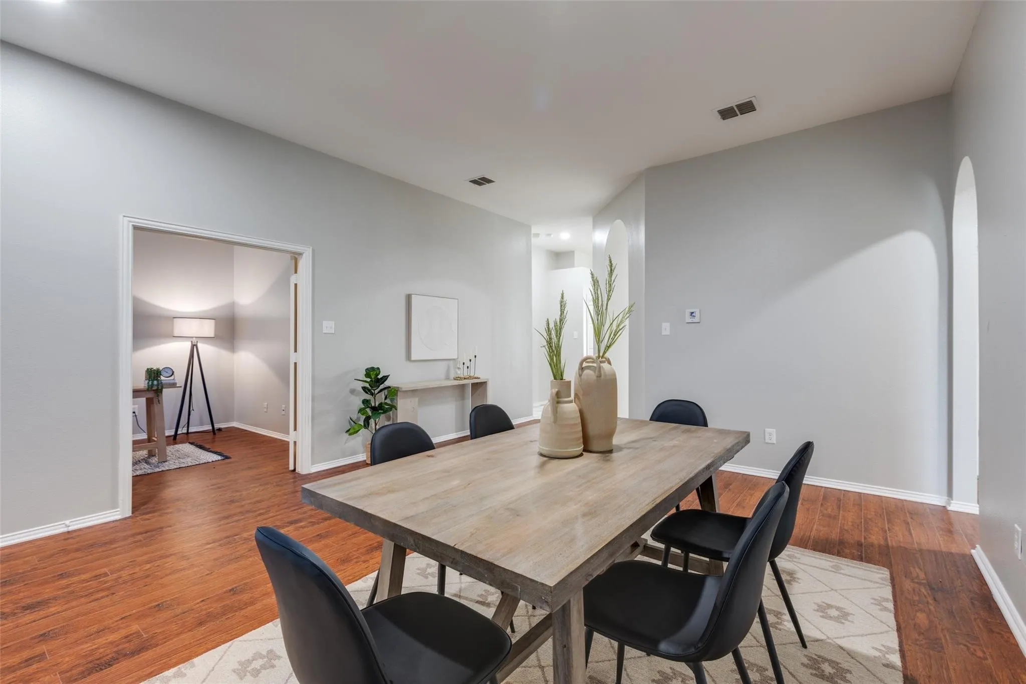 Spacious room featuring wood-finish flooring, light gray walls, and recessed lighting