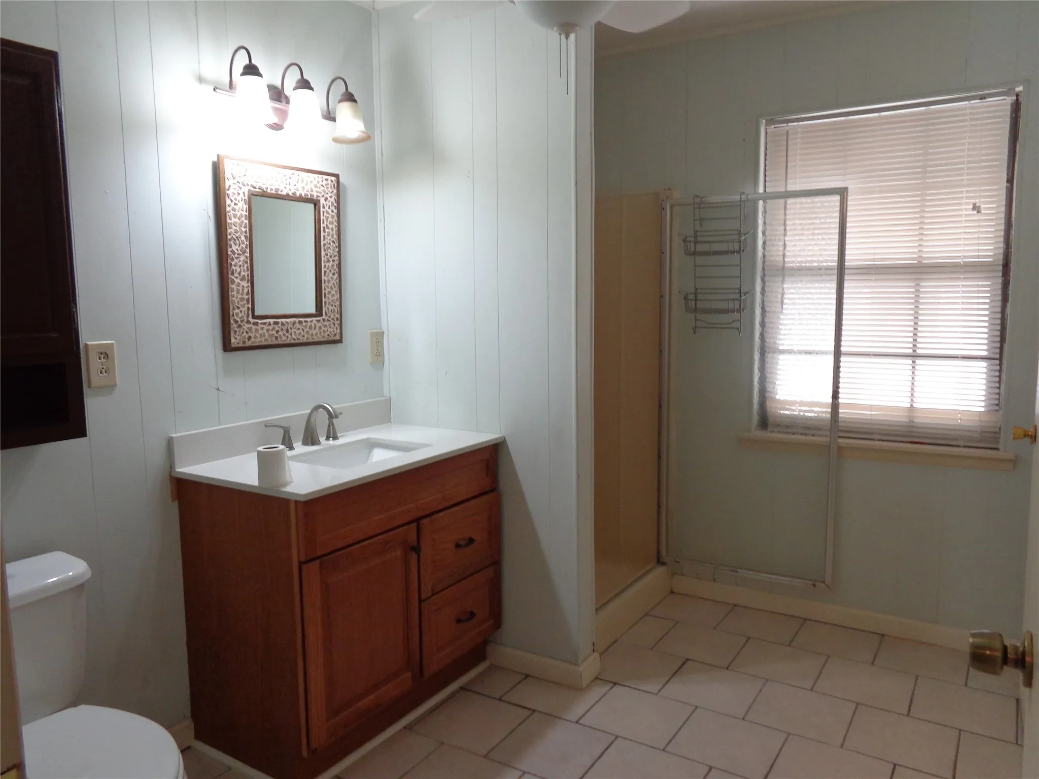 Vanity with wood-finish cabinetry, integrated sink, and white​​‌​​​​‌​​‌‌​‌‌​​​‌‌​‌​‌​‌​​​‌​​ countertop
