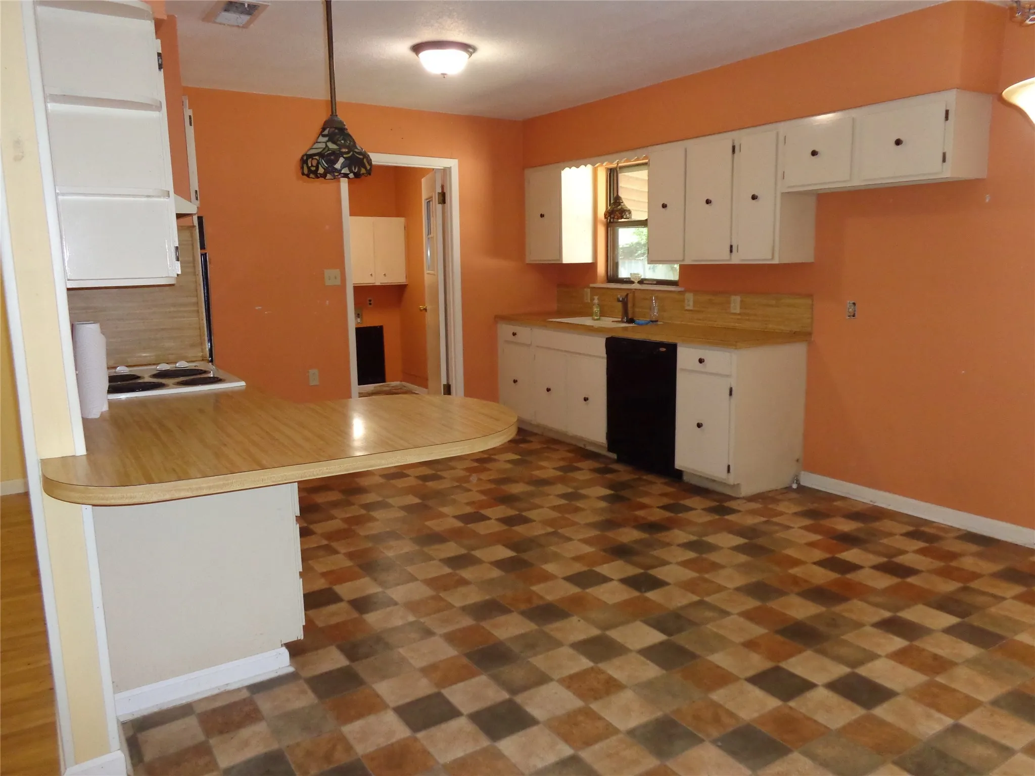Kitchen featuring checkerboard flooring, white cabinetry with black hardware, a built-in electric range, and a dishwasher