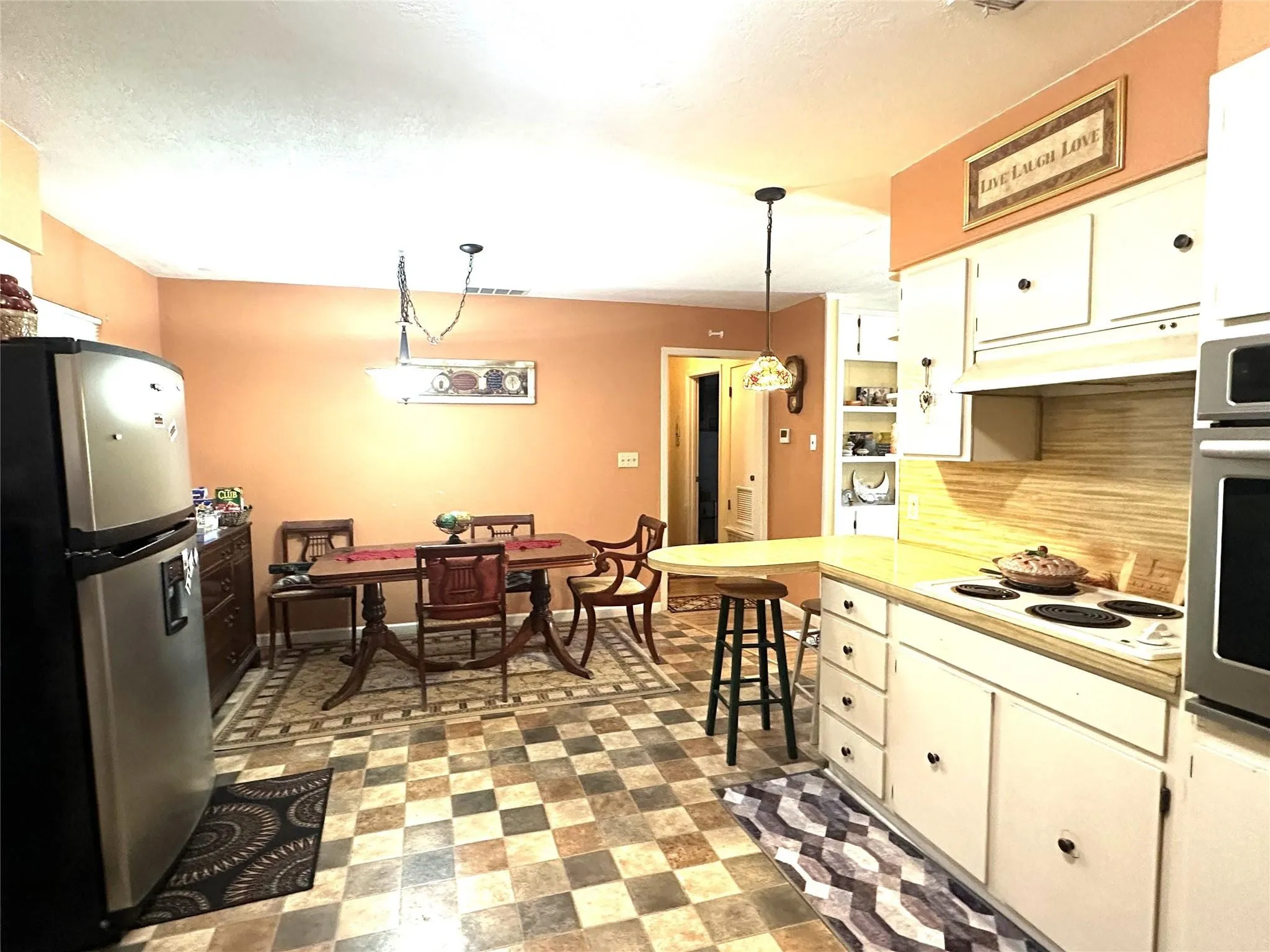 Kitchen featuring checkered tile flooring, white cabinetry, light-toned countertops, and a built-in oven