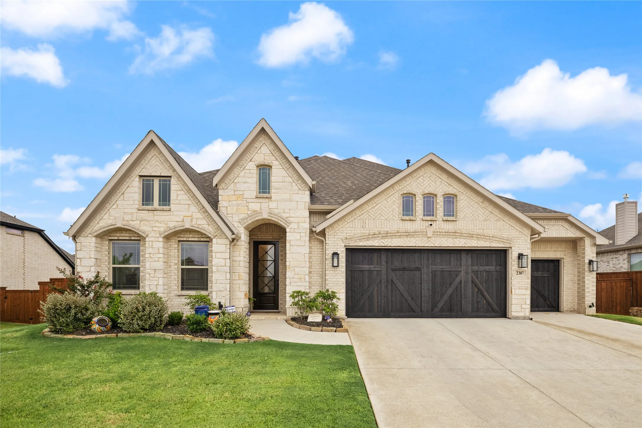Elegant stone-and-brick exterior highlighted by a dramatic multi-gabled roofline and timeless architecture. Brick and stone finish.