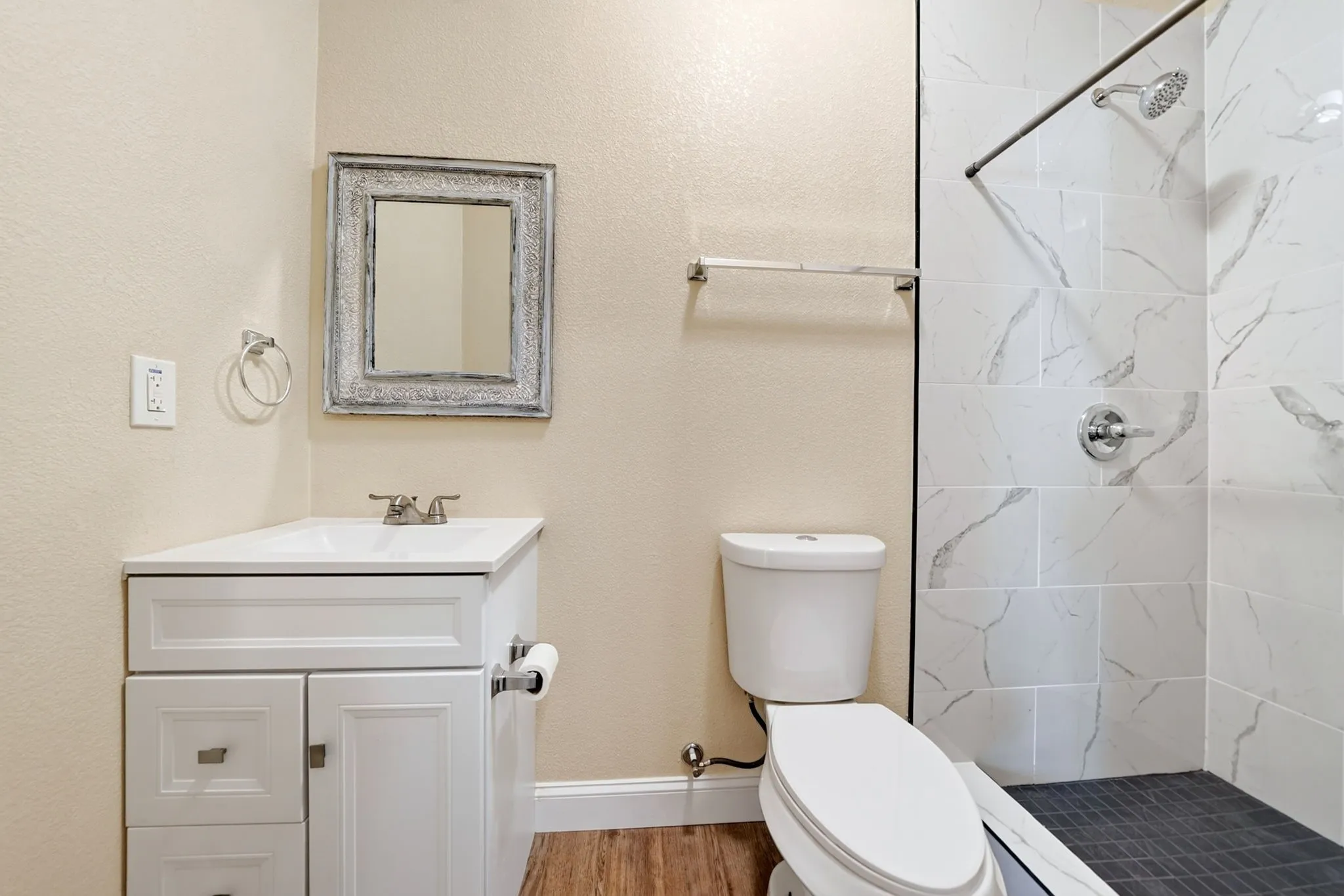 White vanity with integrated sink, chrome faucet, and storage cabinetry