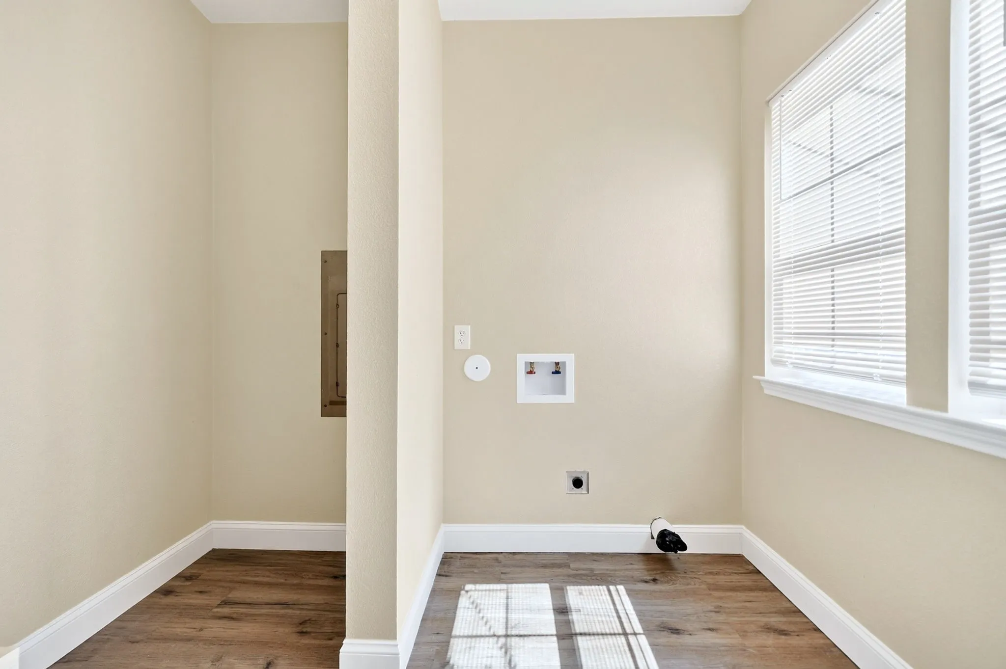 Utility area with wood-finish flooring, a window, and appliance hookups