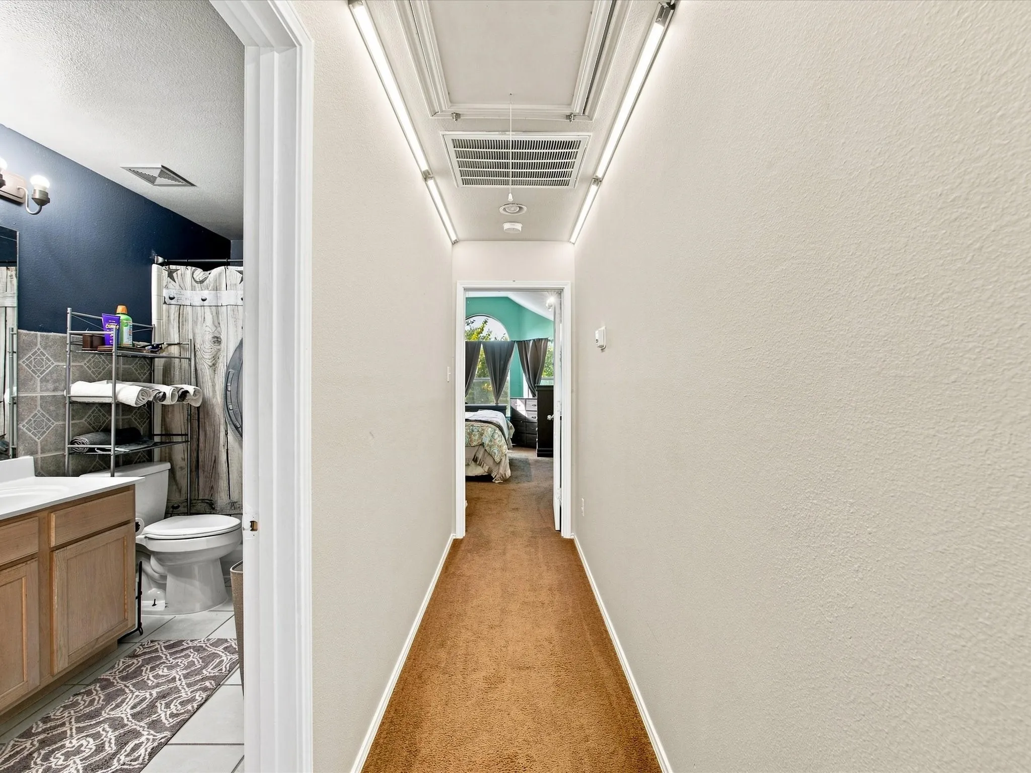 Hallway with ceiling-mounted track lighting and textured walls
